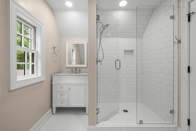 bathroom with vanity, walk in shower, tile patterned floors, and lofted ceiling