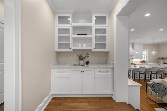 bar featuring white cabinets, light stone countertops, and dark hardwood / wood-style flooring