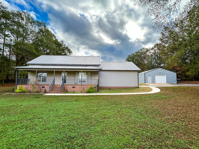 view of front facade with an outbuilding, a garage, covered porch, and a front lawn