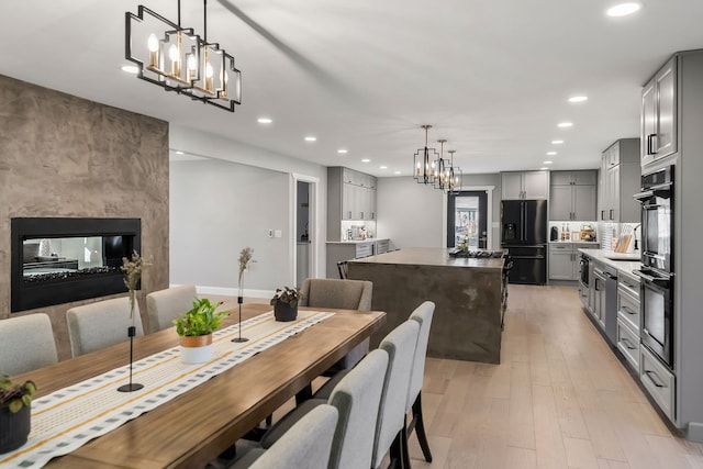 dining space with an inviting chandelier and light hardwood / wood-style flooring