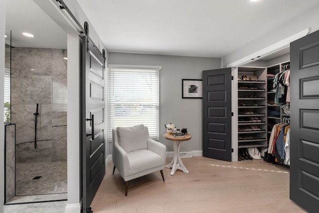 interior space with a barn door and light hardwood / wood-style flooring