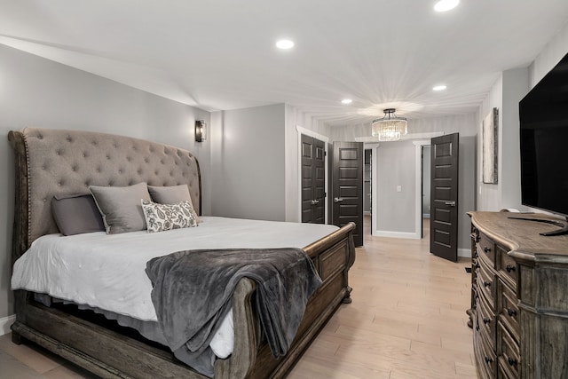 bedroom with light hardwood / wood-style floors and an inviting chandelier