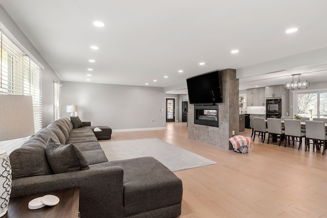 living room featuring light hardwood / wood-style floors and a large fireplace