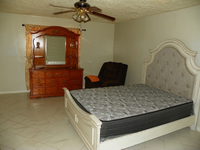 bedroom with ceiling fan and a textured ceiling