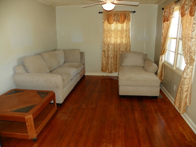 living room featuring dark hardwood / wood-style flooring, ornamental molding, and ceiling fan