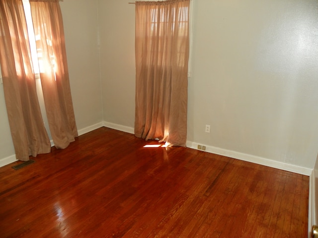 unfurnished room with hardwood / wood-style floors and a healthy amount of sunlight