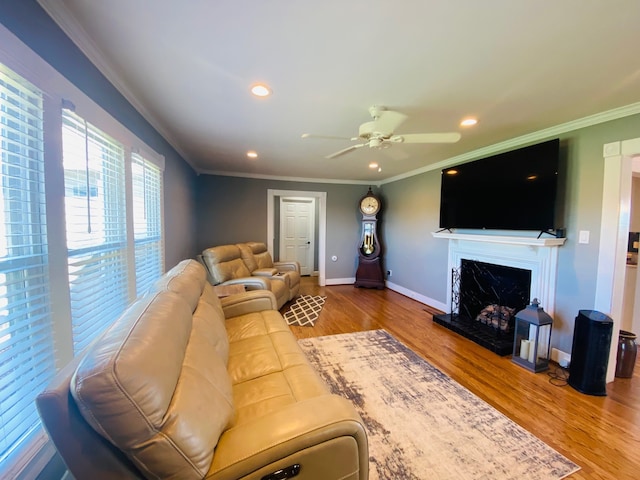 living room featuring hardwood / wood-style floors, ceiling fan, and ornamental molding