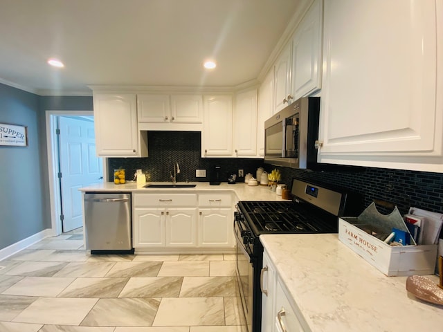 kitchen featuring white cabinetry, decorative backsplash, appliances with stainless steel finishes, and sink