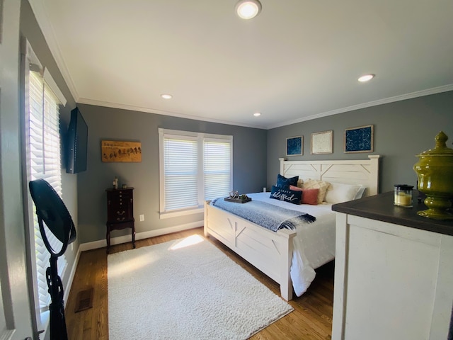 bedroom featuring ornamental molding and hardwood / wood-style floors