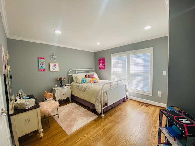 bedroom with hardwood / wood-style flooring and crown molding