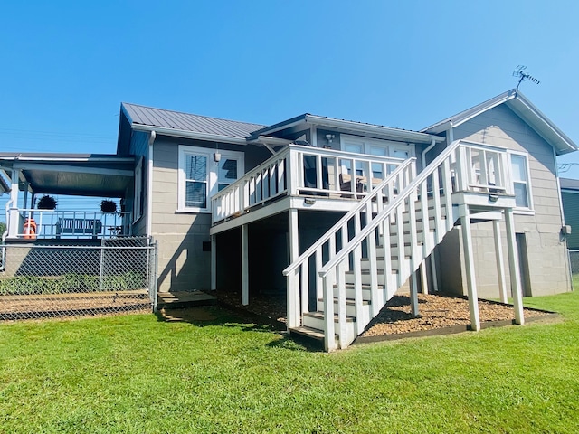 back of house featuring a lawn and a wooden deck