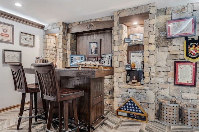 bar with parquet flooring and ornamental molding