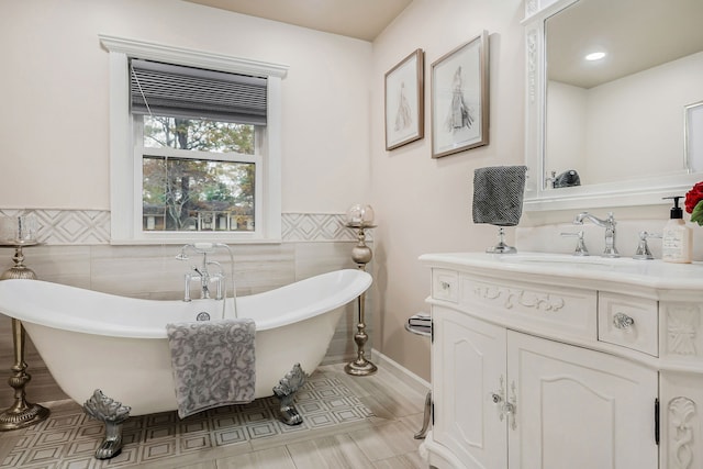 bathroom with vanity, a bathtub, and tile walls