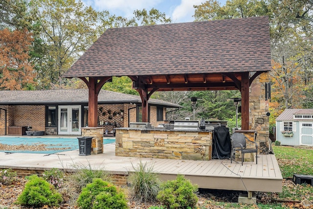 exterior space featuring french doors, a wooden deck, a storage unit, and a gazebo