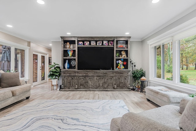 living room featuring crown molding, light wood-type flooring, and french doors