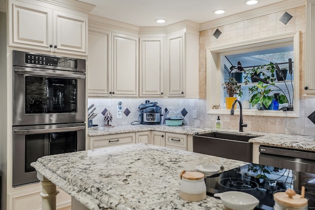 kitchen with tasteful backsplash, light stone counters, sink, and double oven