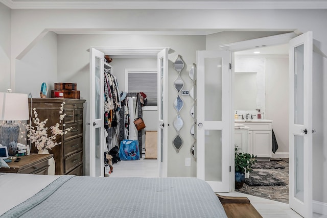 bedroom with a closet, sink, and ornamental molding