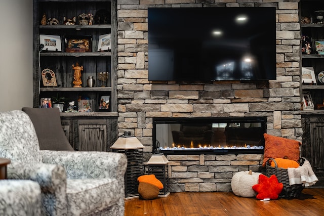 living room featuring hardwood / wood-style flooring and a stone fireplace