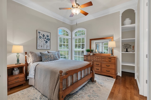 bedroom featuring hardwood / wood-style floors, ceiling fan, and crown molding