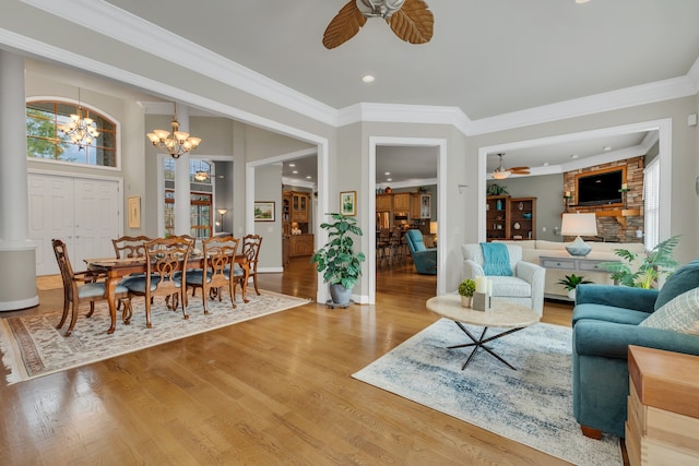 living room with hardwood / wood-style floors, ceiling fan with notable chandelier, and crown molding