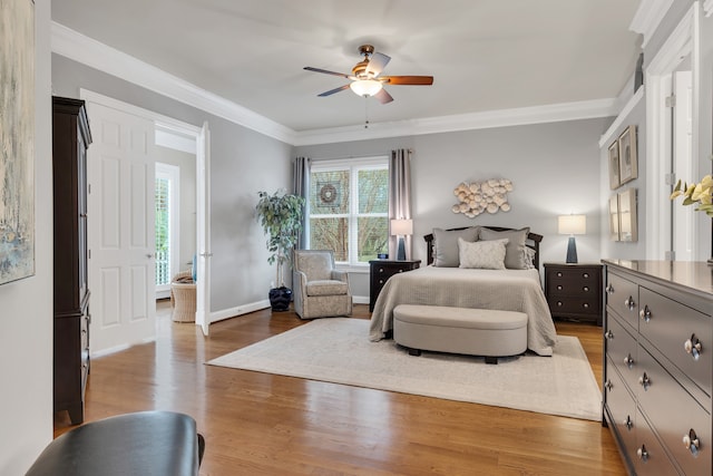 bedroom featuring ceiling fan, ornamental molding, and wood-type flooring