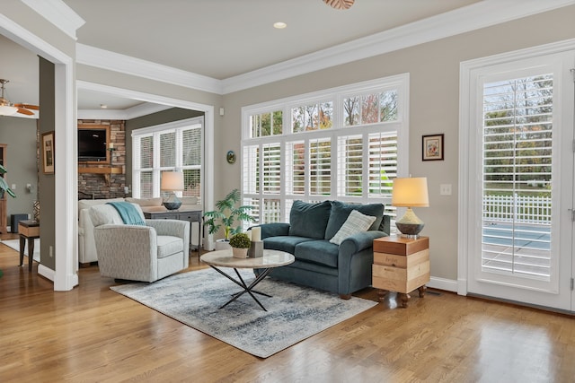 living room featuring ornamental molding, ceiling fan, and light hardwood / wood-style floors