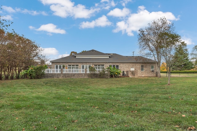 rear view of house featuring a yard