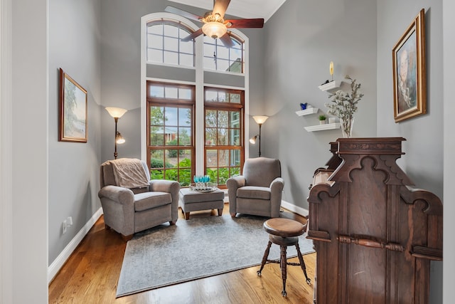 living area featuring a wealth of natural light, ceiling fan, and light hardwood / wood-style floors