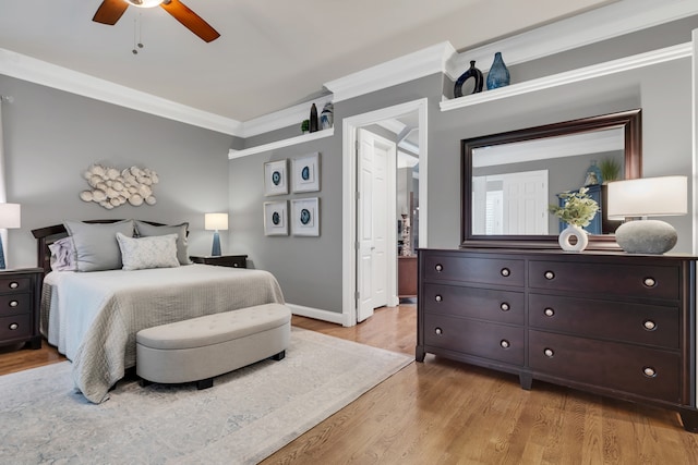 bedroom featuring light wood-type flooring, ceiling fan, and crown molding