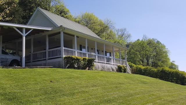 view of side of home featuring a porch and a yard