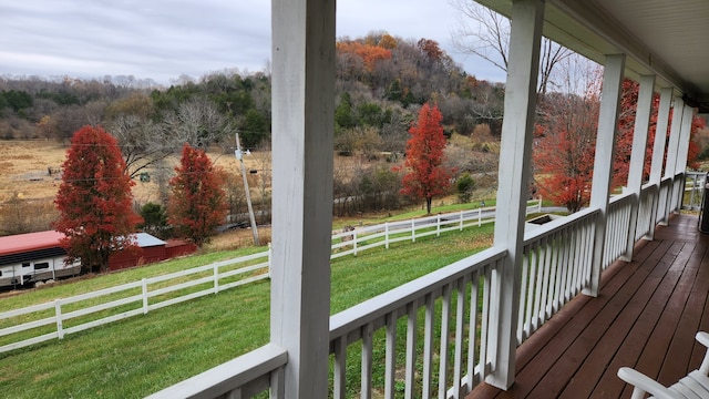 wooden terrace with a lawn and a rural view