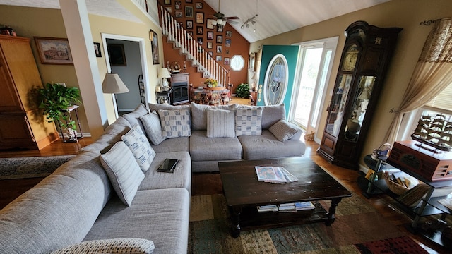 living room featuring dark hardwood / wood-style flooring, lofted ceiling, and ceiling fan