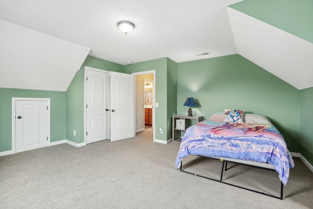 carpeted bedroom with lofted ceiling