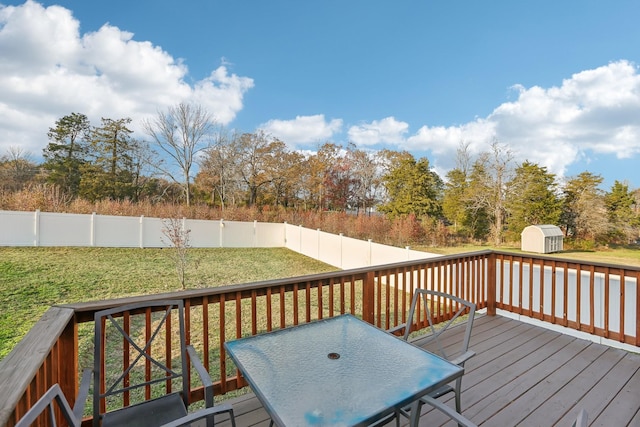 deck featuring a lawn and a storage unit