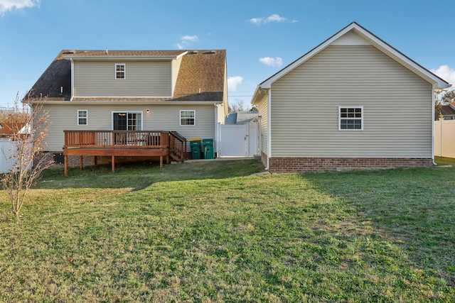 rear view of house with a yard and a wooden deck