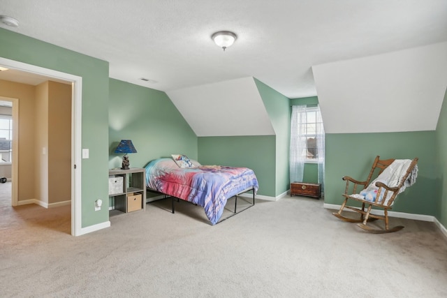 carpeted bedroom with multiple windows and vaulted ceiling