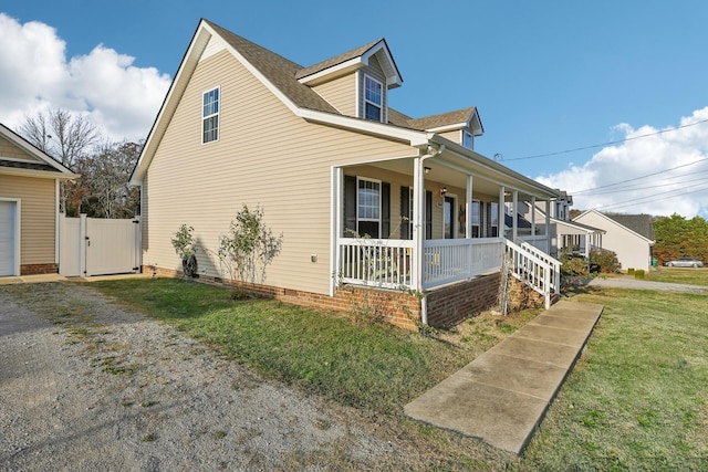 view of side of home with a yard and a porch