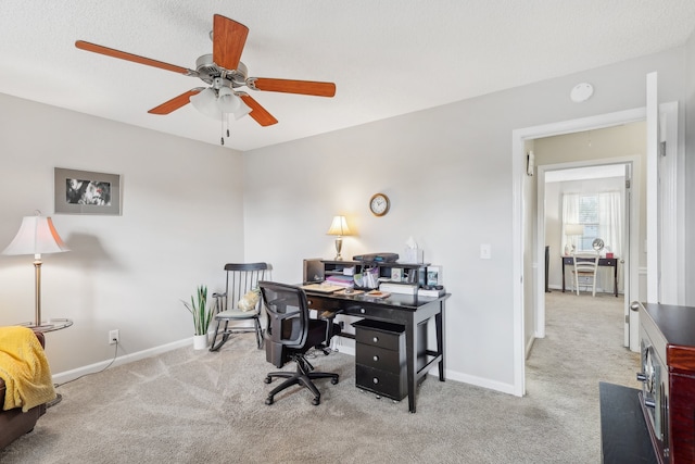 office area featuring a textured ceiling, light colored carpet, and ceiling fan