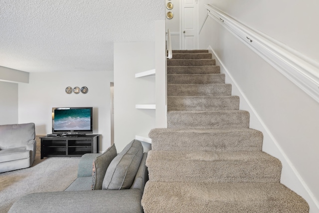 staircase featuring a textured ceiling