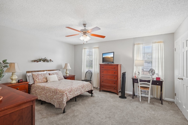 bedroom featuring light carpet, a textured ceiling, and ceiling fan