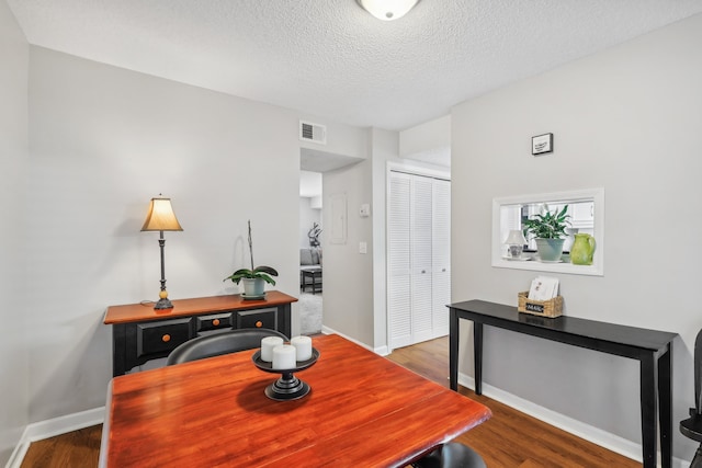 dining space with hardwood / wood-style flooring and a textured ceiling