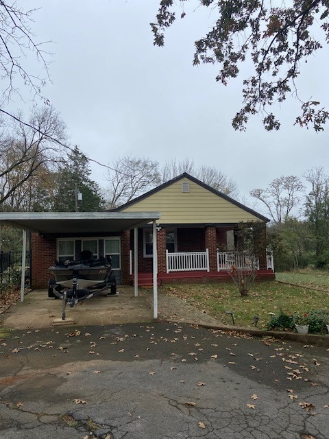 view of front of property featuring a porch and a carport