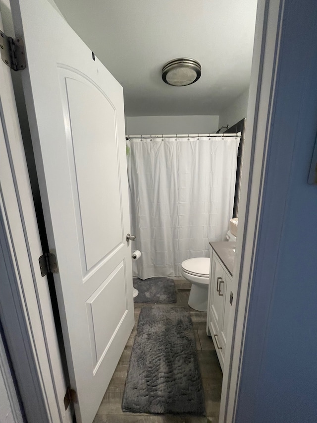 bathroom with hardwood / wood-style floors, vanity, and toilet