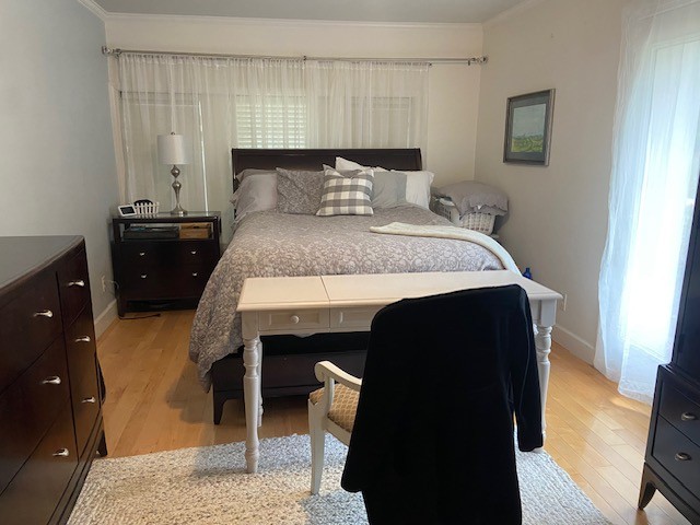 bedroom with crown molding and light hardwood / wood-style flooring