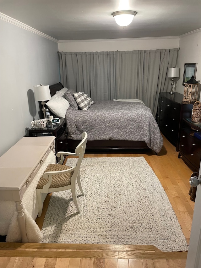 bedroom with hardwood / wood-style floors and crown molding