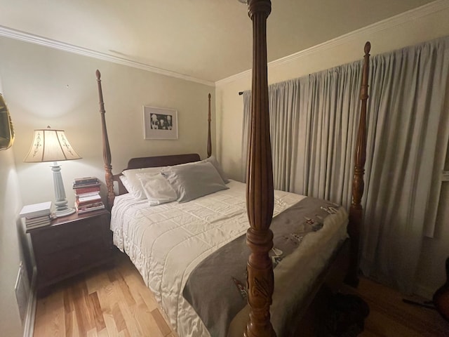 bedroom with wood-type flooring and ornamental molding