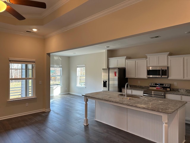 kitchen featuring crown molding, an island with sink, appliances with stainless steel finishes, dark hardwood / wood-style flooring, and white cabinetry