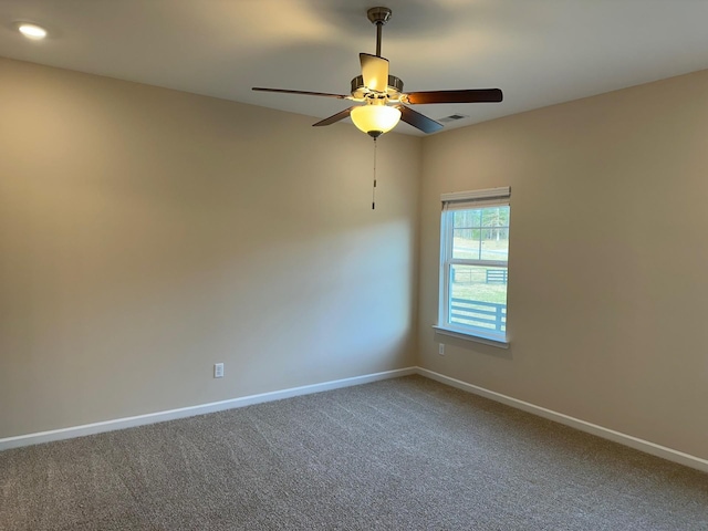 carpeted spare room with ceiling fan