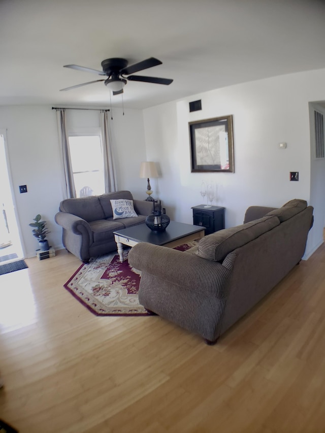 living room with ceiling fan and light hardwood / wood-style flooring