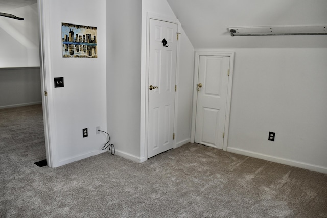 interior space featuring lofted ceiling and light carpet